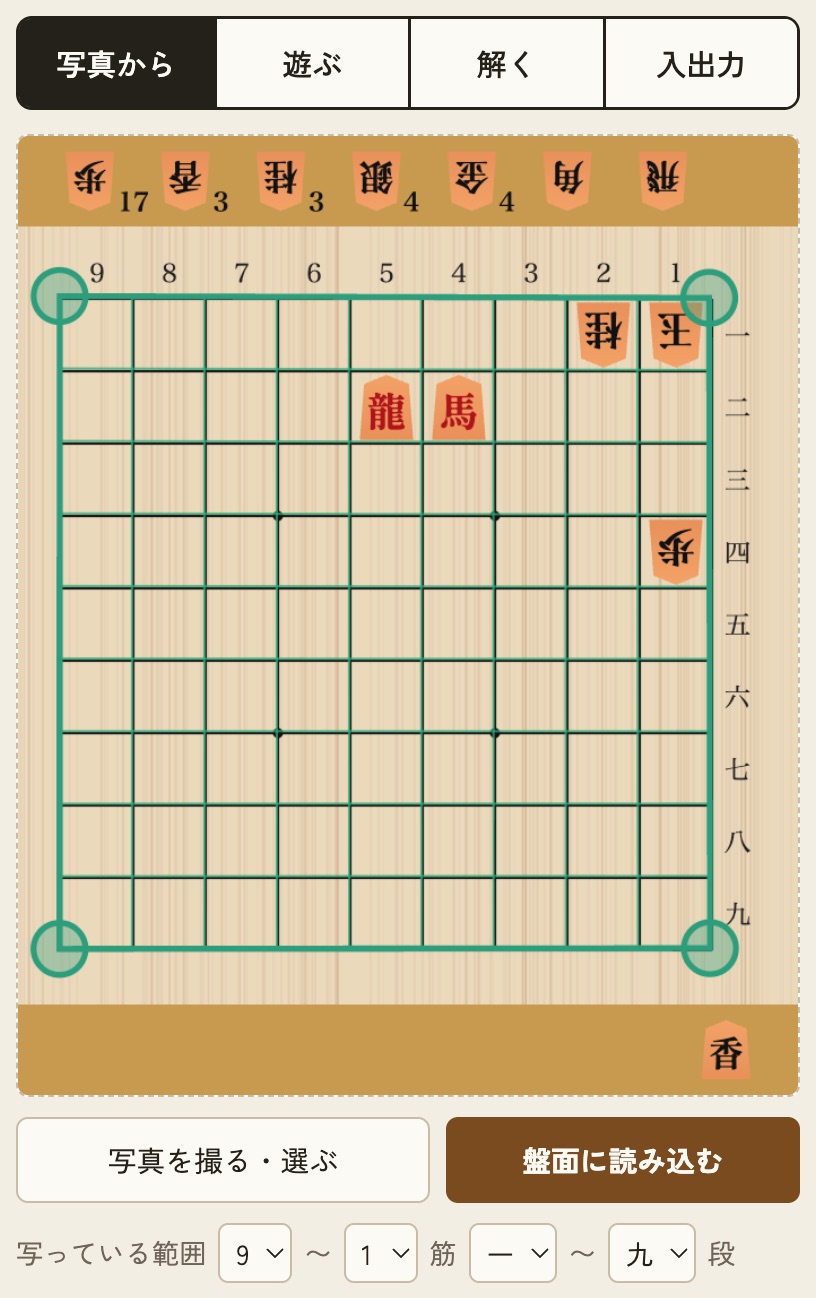 将棋アプリ風の画面のスクショ。木目の盤にオレンジ色の駒、盤の上下の帯に持駒が駒の絵と枚数で並んでいる